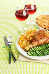 Roast chicken with french fries and cucumbers, glasses of wine