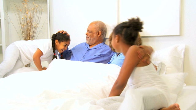African American Grandparents Talking Grandchildren Bed