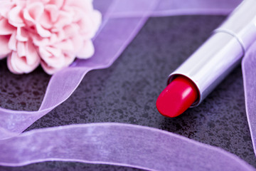 Obraz na płótnie Canvas red lipstick on black with decorative objects