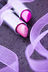 macro of pink lipsticks on black