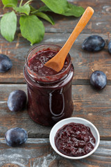Homemade plum jam on wooden table