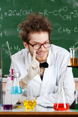 Mad professor surrounded with chemical glassware