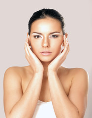 A young woman touching her face, closeup