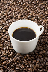 コーヒー豆の背景にコーヒーカップ