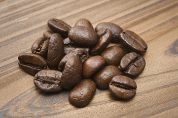 木目の背景に複数のコーヒー豆