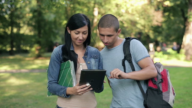 Young students with tablet computer in the park