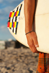 closeup of a surfer holding a surfboard
