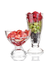 Mixed fruits and berries in glasses isolated on white