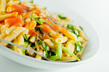 pasta with vegetables on white dish closeup