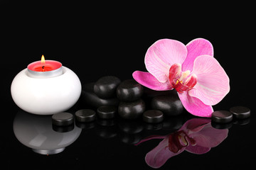 Obraz na płótnie Canvas Kamienie spa z kwiat orchidei i świeca odizolowane na czarno