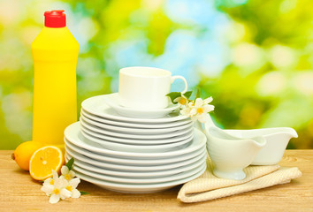 empty clean plates and cups with dishwashing liquid, flowers