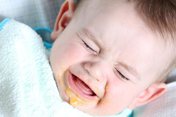 Crying baby boy eating vegetable mash