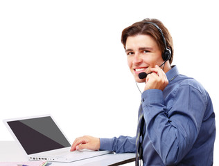 Young businessman with headset in front of laptop