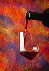 Fotobehang Red wine pouring in glass over grange background © SJ Travel Footage