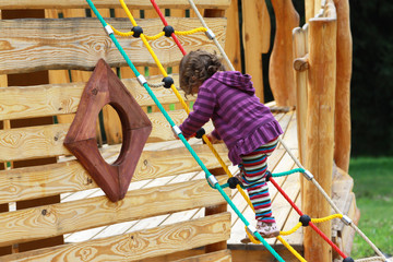 Ein Mädchen spielt auf einem Spielplatz - obrazy, fototapety, plakaty