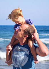 папа с дочкой гуляют вдоль берега