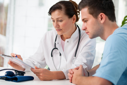 &Auml;rztin ber&auml;t einen jungen Patienten