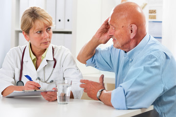 Ärztin spricht mit älteren Patienten
