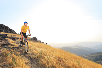 A young male riding a mountain bike on a sunset