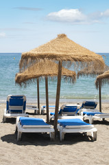 Straw beach umbrellas and sunbeds