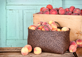 Many peaches in wooden crate and basket