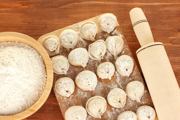 Raw Dumplings on cutting board on wooden background close-up