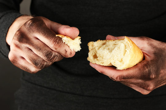 homeless man holding a white bread, close-up