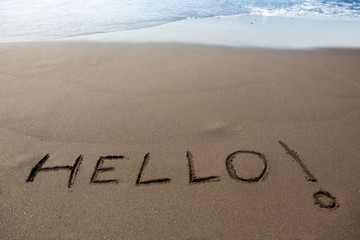 Brown sand beach with written word Hello