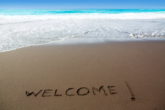 Brown sand beach with written word Welcome