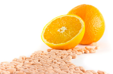 Vitamin c tablet with orange fruit on white background