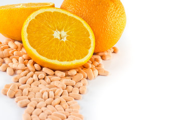 Orange fruit with vitamin c tablet on white background