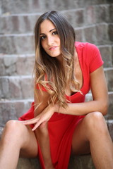 Ragazza con vestito rosso sulla scala