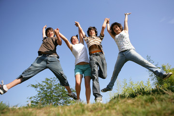four teenagers jumping