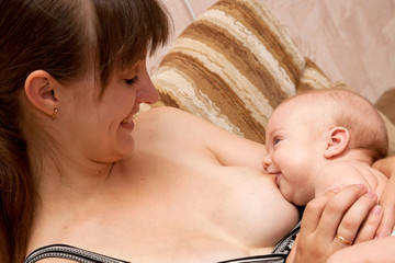 child and the mother are looking eye to eye and smiling