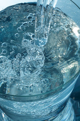 Pouring a mineral water into a glass, close up