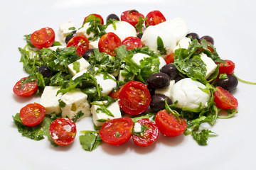 Insalata con rucola, feta, olive nere, mozzarella e pomodorini