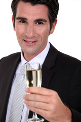 A businessman with a flute of champagne.