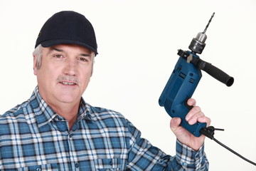 Elderly man holding an electric screwdriver