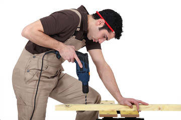 Man drilling hole in wood