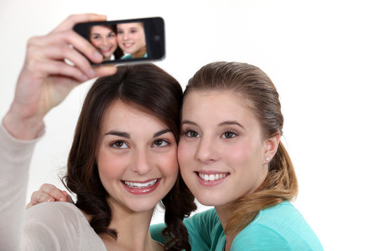 Girls taking picture with mobile phone