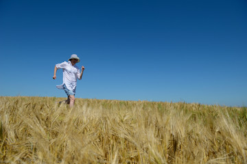 Naklejka na ściany i meble young woman in wheat field at summer