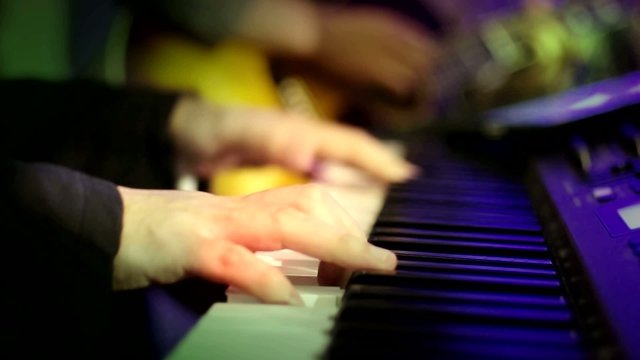 Hand of the Pianist Playing Electric Piano with Lighting
