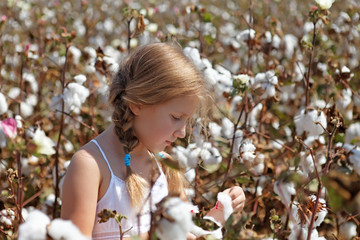 Young girl walking in a field of cotton