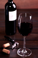 Red wine glass and bottle on a table
