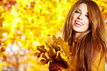 Naklejka na ściany i meble Portrait of beautiful young woman in autumn park.
