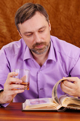 cute man with whiskey reading