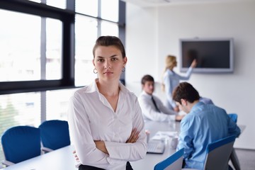 business woman with her staff in background at office