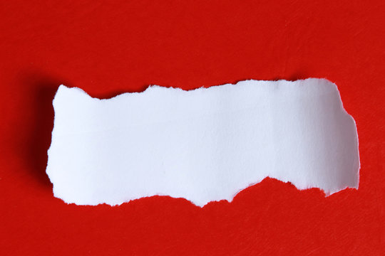 A torn peice of paper on red