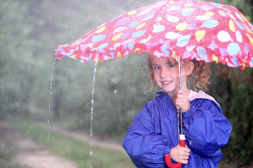 Little girl with umbrella in a rainy day