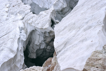 Deep crack in the glacier in the mountains